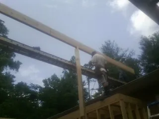 Carpenter setting a ridge beam over a new addition frame — Ice Dam Removal by Roofing Brothers in Center Rutland