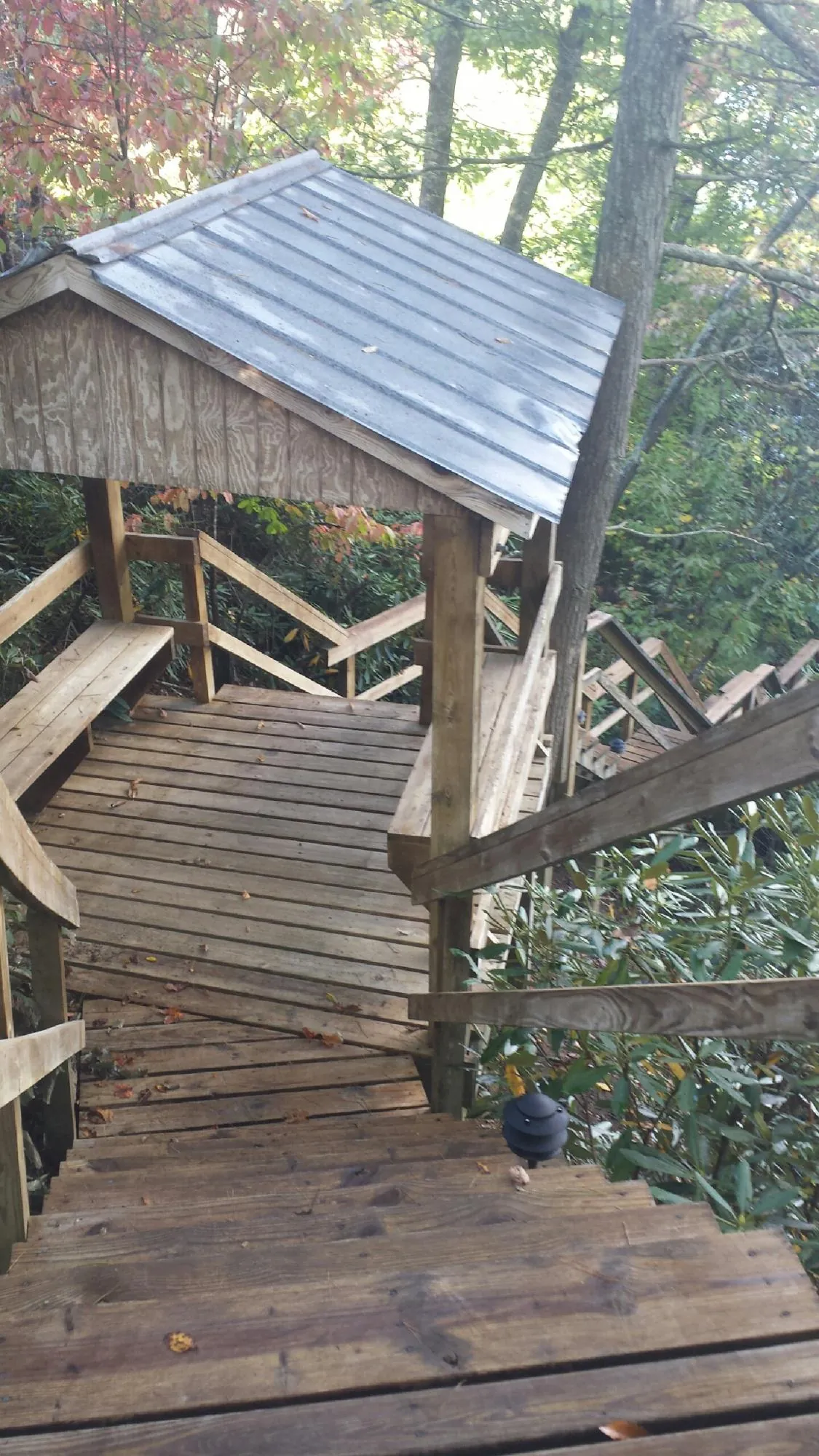 Metal roofed shelter over wooden steps on a wooded walkway — Skylight Repair & Installation work by our crew in Center Rutland