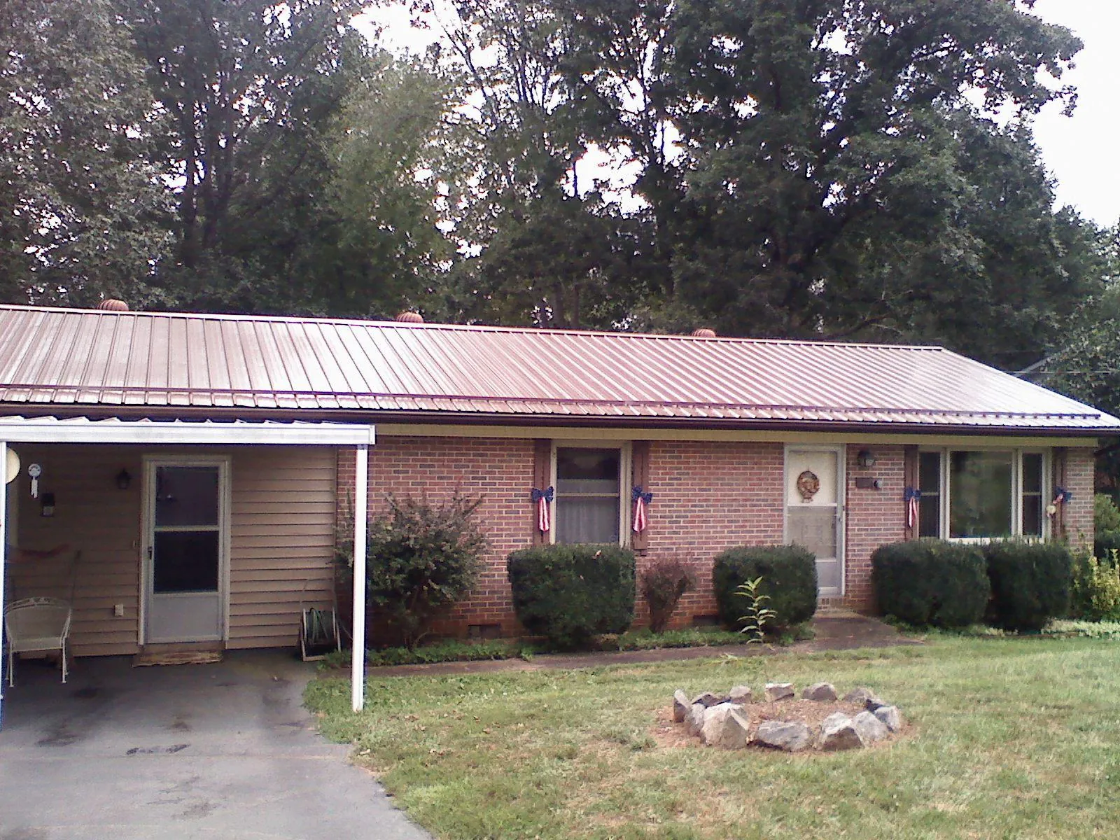 Bronze metal roof and carport on a brick ranch home — Roof Repair work by our crew in Center Rutland